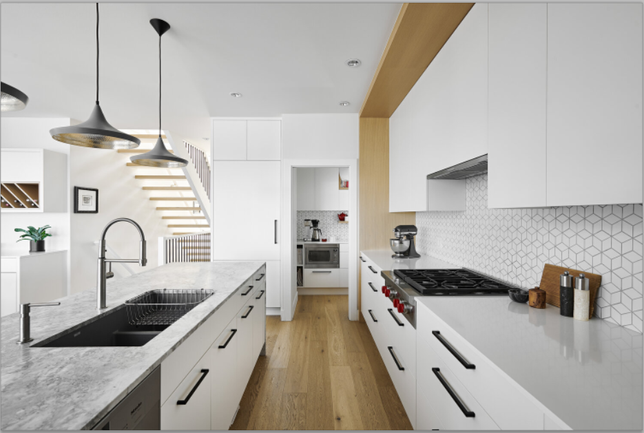 Clean, bright white kitchen with black hardware and accessories.
