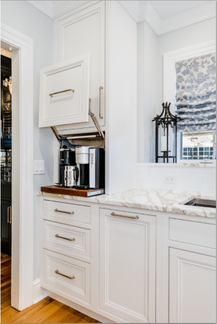 An amazing lift system and gold decorative hardware give this kitchen a high end look and much energy
