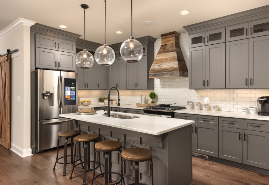 Neutral gray cabinetry is beautifully accented with oil rubbed bronze accents and distressed barn wood.