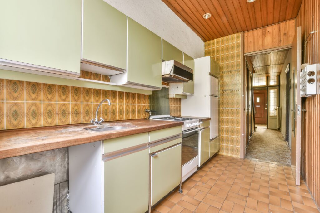 old fashioned kitchen with green cabinets and a white fridge