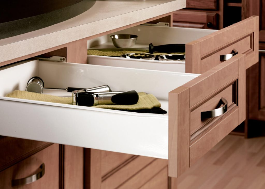 Open wooden vanity drawer with makeup itemslipstick brush and compact on a beige cloth inside a white inner drawer