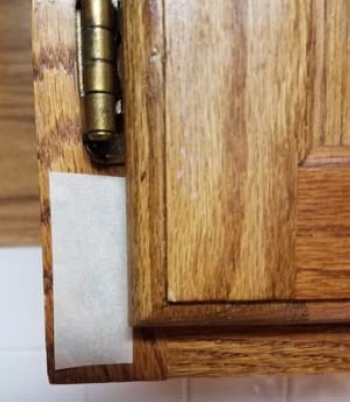 Figure 2 - Place a piece of tape on the cabinet face.